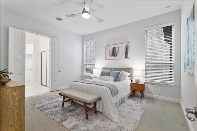 bedroom featuring light colored carpet, baseboards, and a ceiling fan