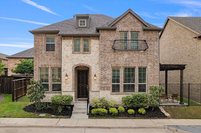 view of front of home with fence, a balcony, brick siding, roof with shingles, and a pergola