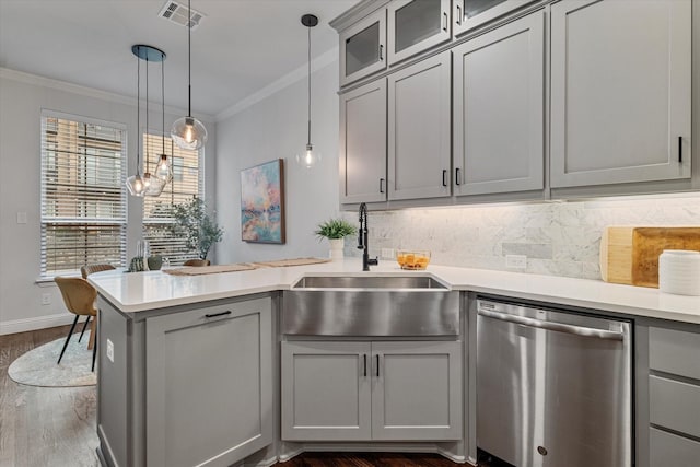 kitchen featuring stainless steel dishwasher, a peninsula, gray cabinetry, ornamental molding, and dark wood finished floors