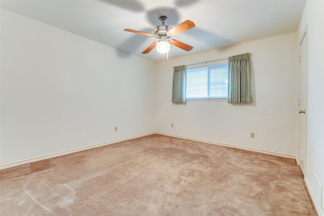 spare room featuring carpet floors, baseboards, and ceiling fan