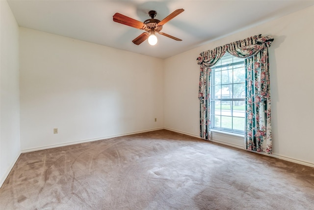 spare room with carpet floors, a ceiling fan, and baseboards