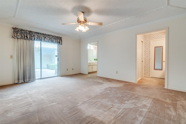 spare room with light colored carpet, a textured ceiling, ceiling fan, and baseboards
