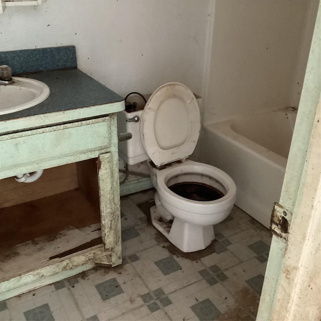 full bath with vanity, tile patterned floors, toilet, and a washtub
