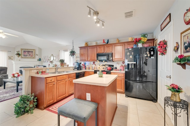 kitchen with visible vents, a peninsula, ceiling fan, a sink, and black appliances