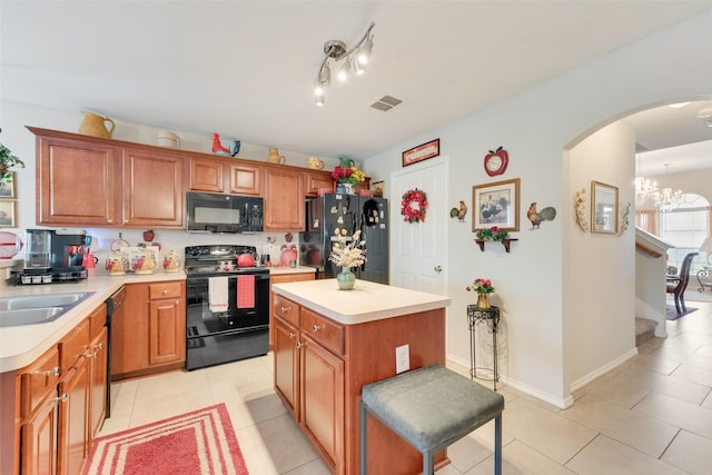 kitchen with visible vents, light countertops, arched walkways, light tile patterned floors, and black appliances