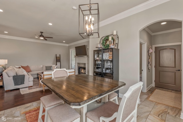 1113 Cypress Creek Cir, Shreveport, LA 71106 - dining space featuring a fireplace, arched walkways, a ceiling fan, recessed lighting, and ornamental molding
