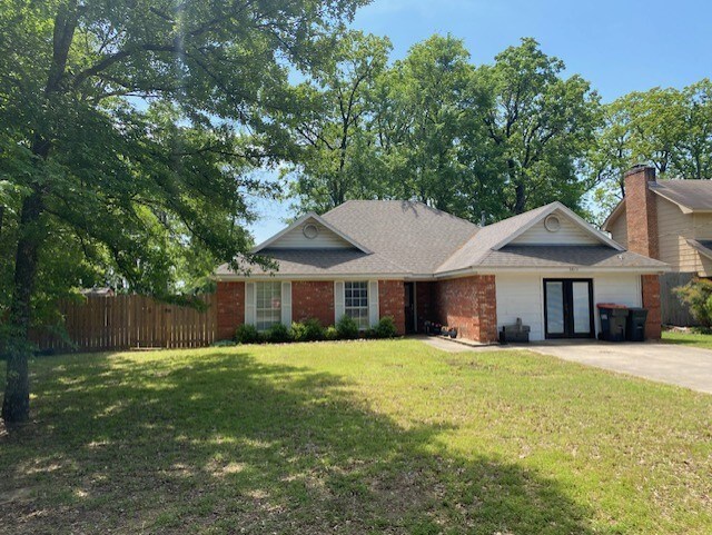 single story home with fence, driveway, a front lawn, and french doors