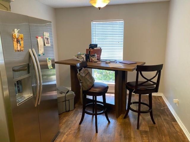 dining room featuring dark wood-type flooring and baseboards