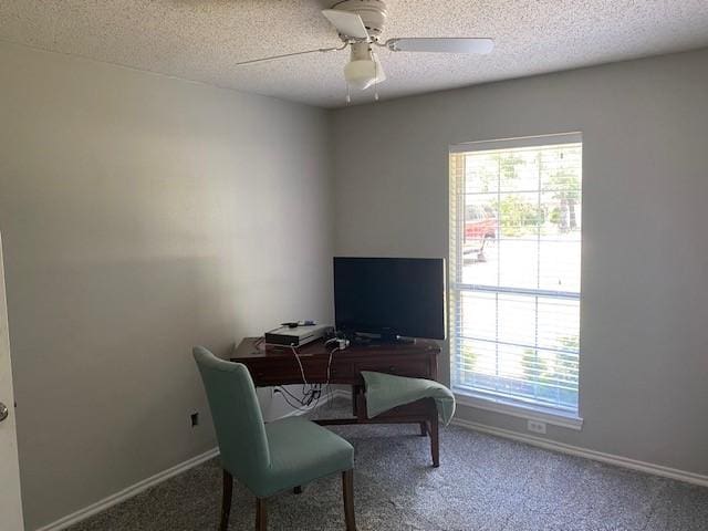 carpeted home office with baseboards, a textured ceiling, ceiling fan, and a wealth of natural light