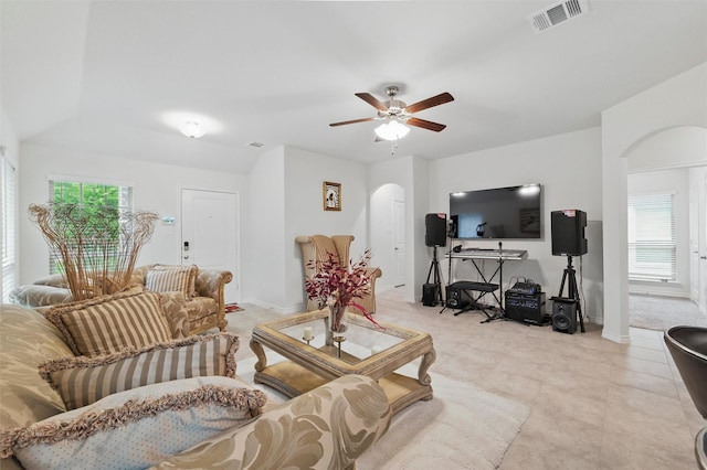 living room featuring visible vents, arched walkways, ceiling fan, and a healthy amount of sunlight