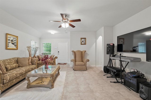 living area featuring baseboards and a ceiling fan
