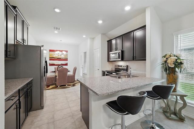 kitchen featuring appliances with stainless steel finishes, a wealth of natural light, a peninsula, and visible vents