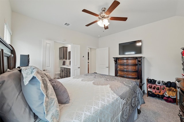 carpeted bedroom with ceiling fan, connected bathroom, and visible vents