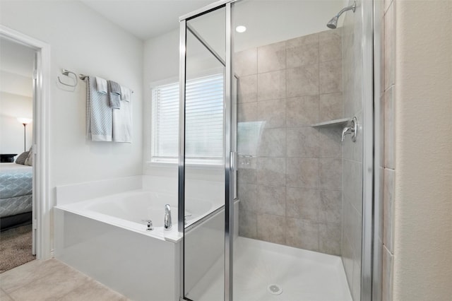 ensuite bathroom featuring a garden tub, connected bathroom, tile patterned flooring, and a shower stall