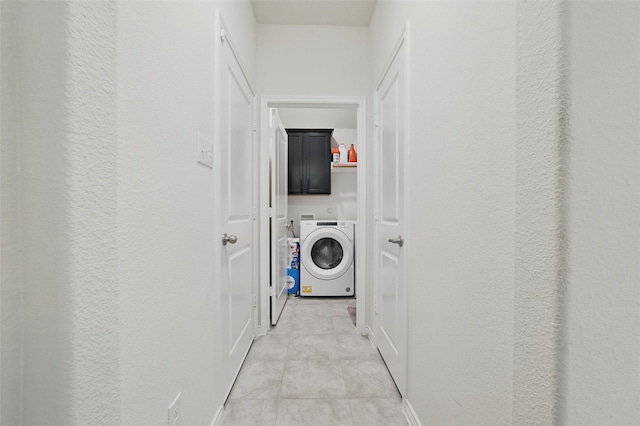clothes washing area featuring washer / dryer, baseboards, and cabinet space