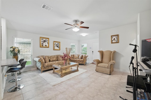 living room with light tile patterned floors, baseboards, a ceiling fan, and visible vents