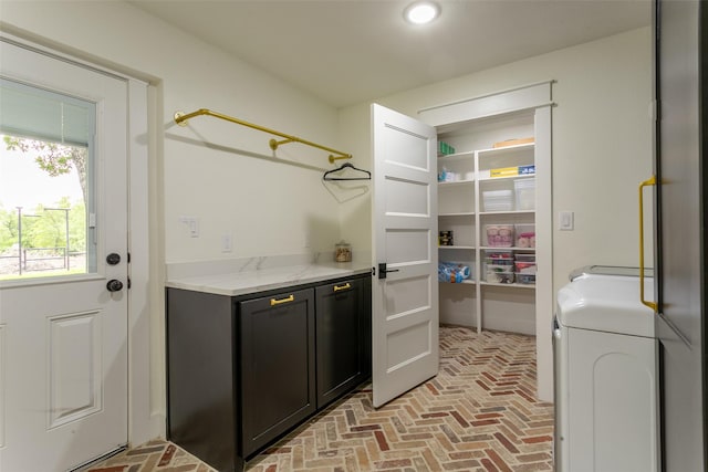 washroom featuring brick floor, recessed lighting, cabinet space, and washing machine and clothes dryer