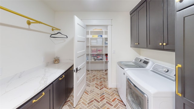 laundry area featuring cabinet space, brick floor, and washing machine and dryer