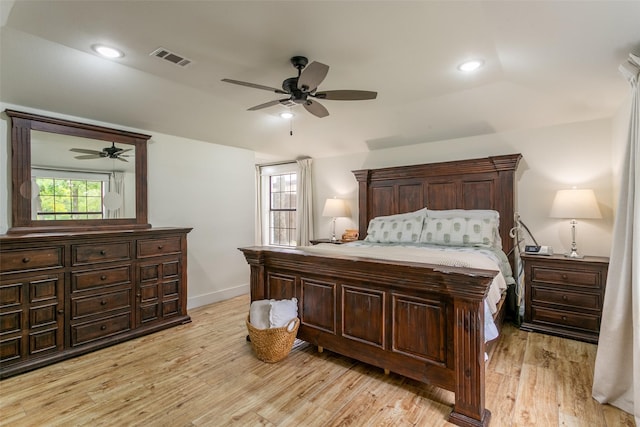 bedroom featuring a ceiling fan, baseboards, vaulted ceiling, light wood-type flooring, and visible vents