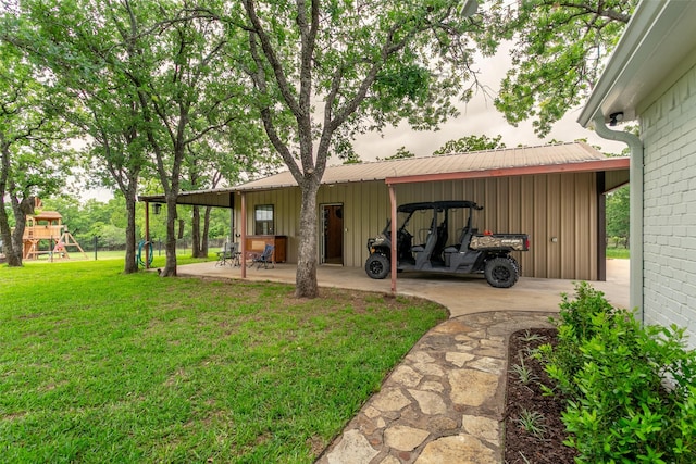 rear view of property featuring a playground, board and batten siding, a yard, and metal roof