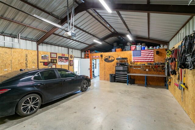 garage featuring a workshop area, a garage door opener, and metal wall