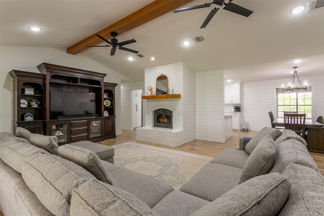 living room with vaulted ceiling with beams, ceiling fan with notable chandelier, light wood-style flooring, and visible vents