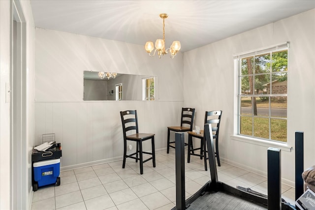 dining area featuring an inviting chandelier, baseboards, and tile patterned flooring