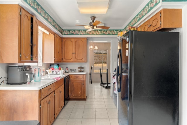 kitchen featuring brown cabinetry, light countertops, a ceiling fan, light tile patterned floors, and black appliances