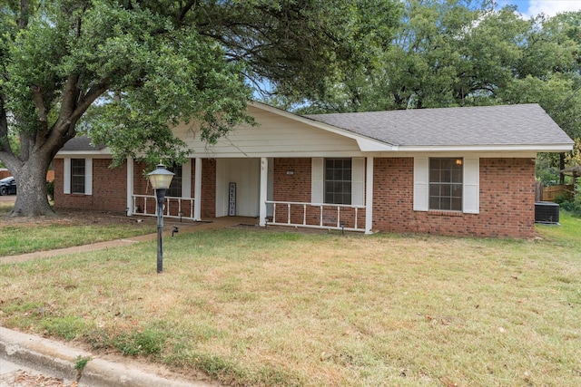 ranch-style house with covered porch, brick siding, central AC, and a front yard