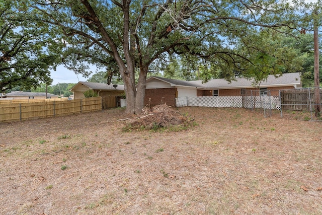 back of house with brick siding and a fenced backyard