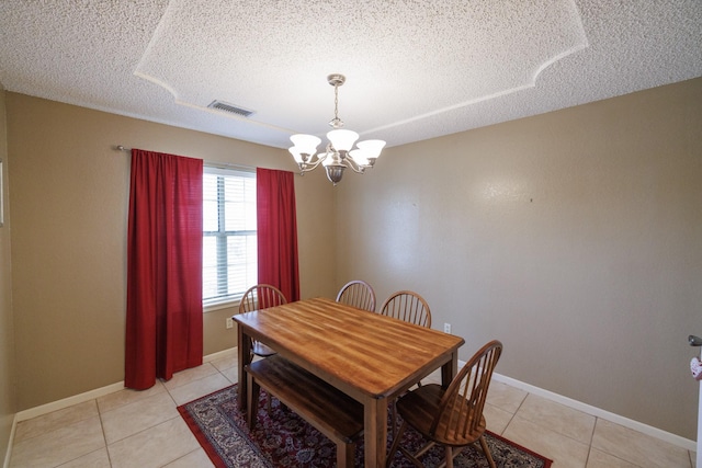 dining space featuring a chandelier, light tile patterned flooring, a textured ceiling, and visible vents