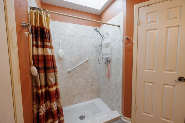 bathroom with a stall shower and a skylight