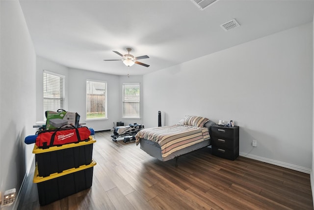 bedroom with ceiling fan, baseboards, visible vents, and wood finished floors