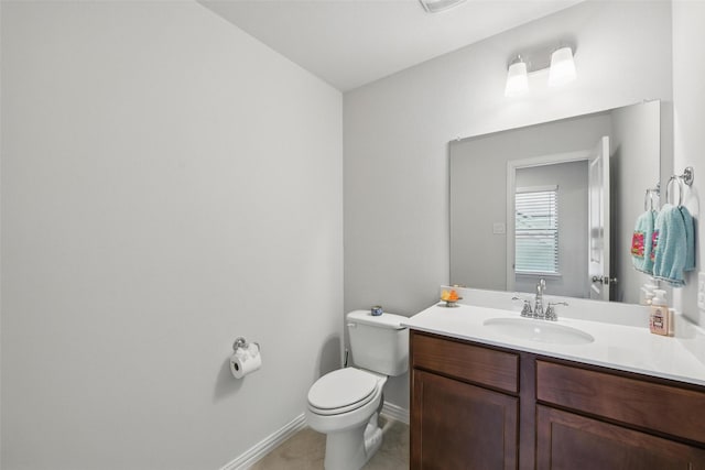 bathroom with vanity, baseboards, tile patterned floors, and toilet