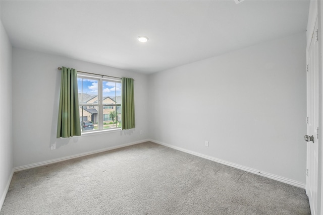 unfurnished room with baseboards and carpet flooring
