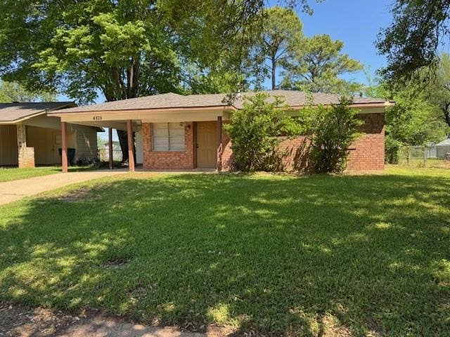 ranch-style house with brick siding, driveway, a front yard, and an attached carport
