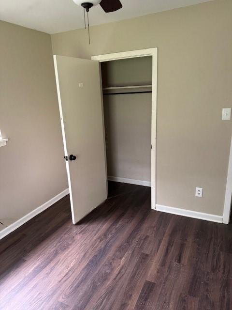 unfurnished bedroom with a closet, baseboards, ceiling fan, and wood finished floors