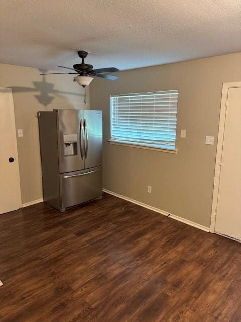 unfurnished dining area featuring a textured ceiling, ceiling fan, and dark wood finished floors
