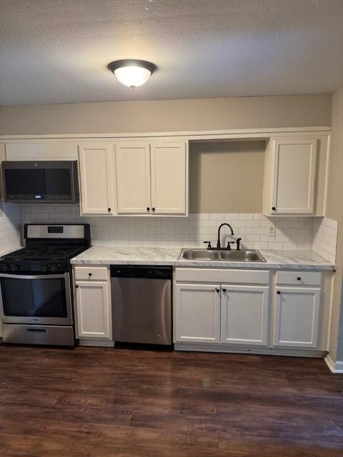 kitchen with a sink, light countertops, stainless steel appliances, and white cabinetry