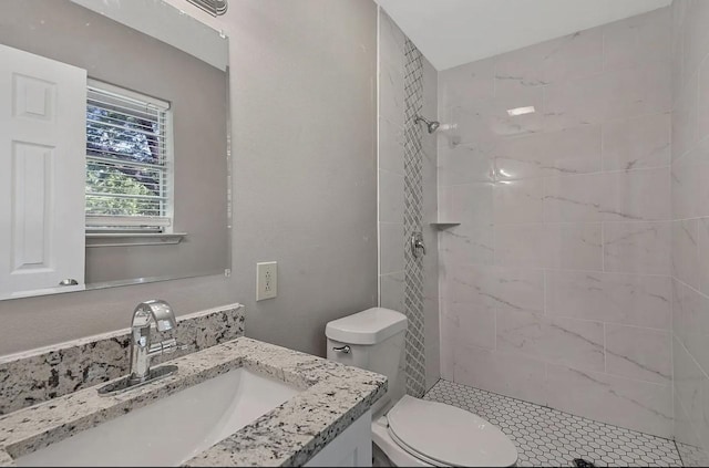 full bathroom featuring vanity, toilet, and tiled shower