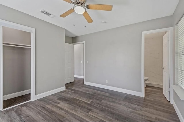 unfurnished bedroom featuring a closet, baseboards, dark wood-type flooring, and visible vents