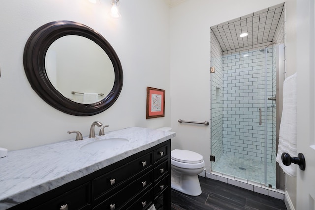 full bath featuring crown molding, a shower stall, wood finished floors, vanity, and toilet