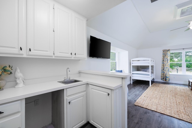 kitchen featuring a sink, light countertops, white cabinets, and a peninsula