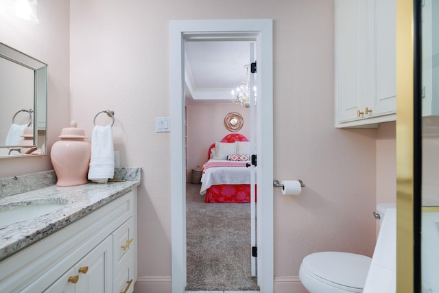 ensuite bathroom with vanity, ensuite bathroom, a notable chandelier, and toilet