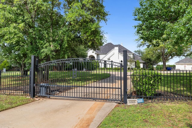 view of gate with fence and a yard