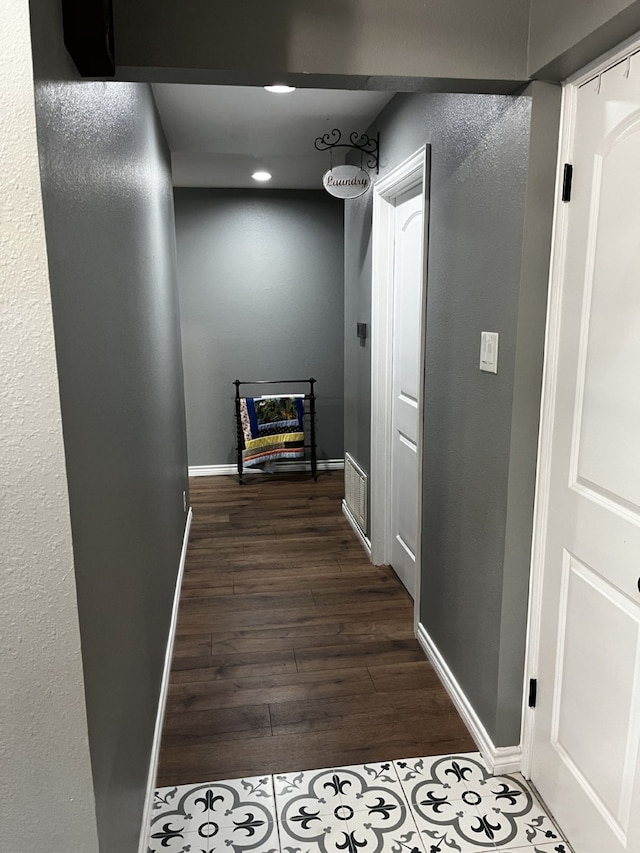 hallway with dark wood-type flooring and baseboards