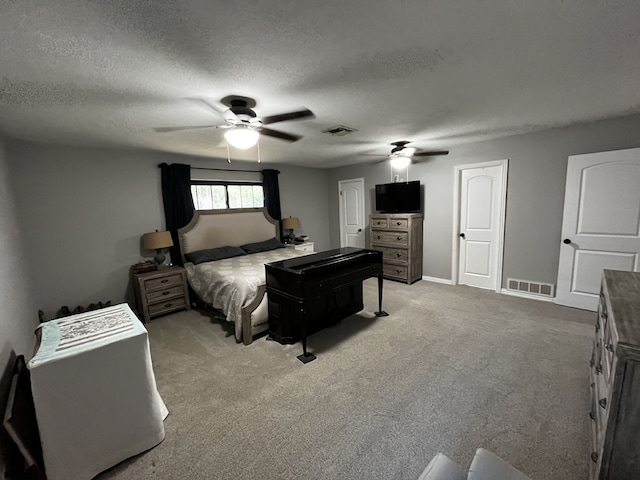 carpeted bedroom featuring a ceiling fan, a textured ceiling, and visible vents