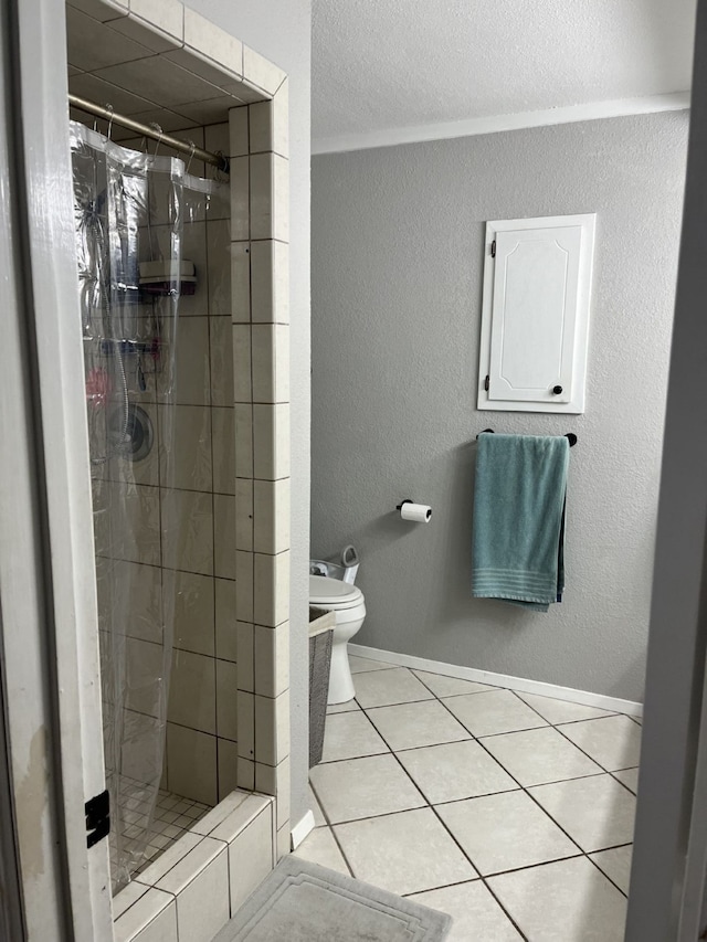 full bathroom featuring toilet, a textured wall, tiled shower, and tile patterned flooring