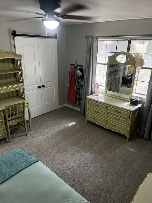 bedroom featuring dark carpet, a ceiling fan, and a closet