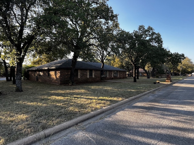 view of front of property with a front lawn and brick siding